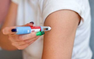 Girl injecting the drug Ozempic into her arm for weight loss