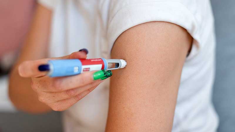 Girl injecting the drug Ozempic into her arm for weight loss